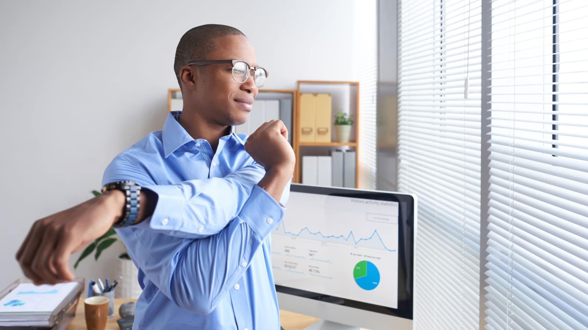 Man standing and stretching at office.