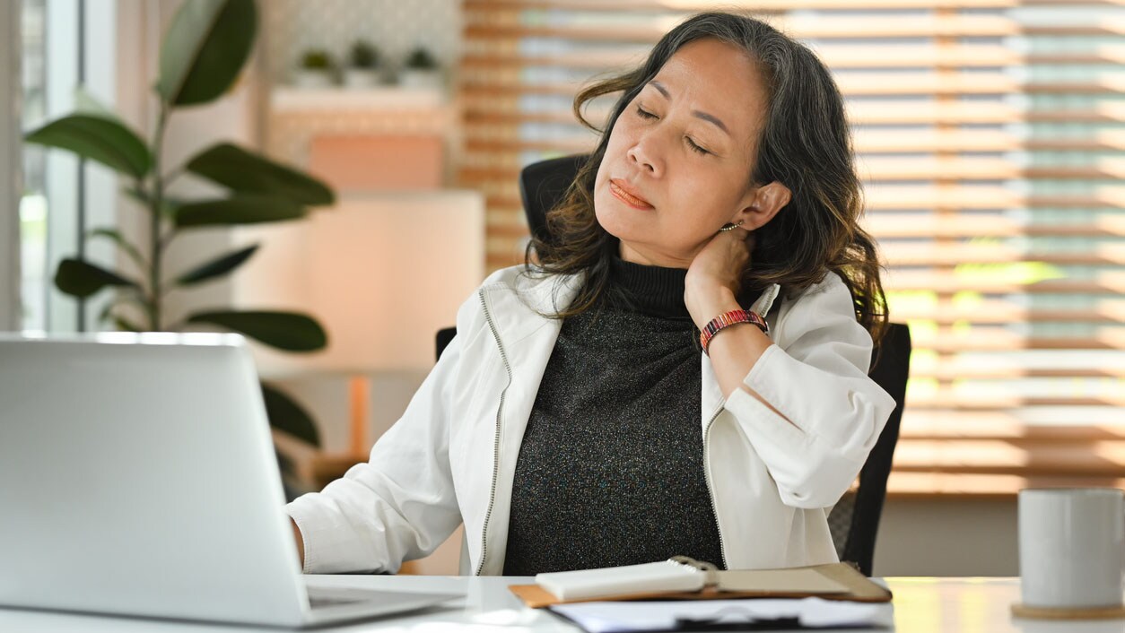 Woman rubbing her neck from pain and stiffness.