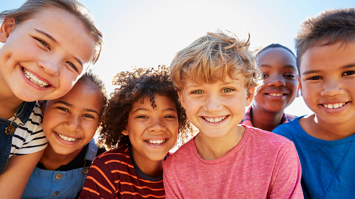 A group of children gathered and smiling together.
