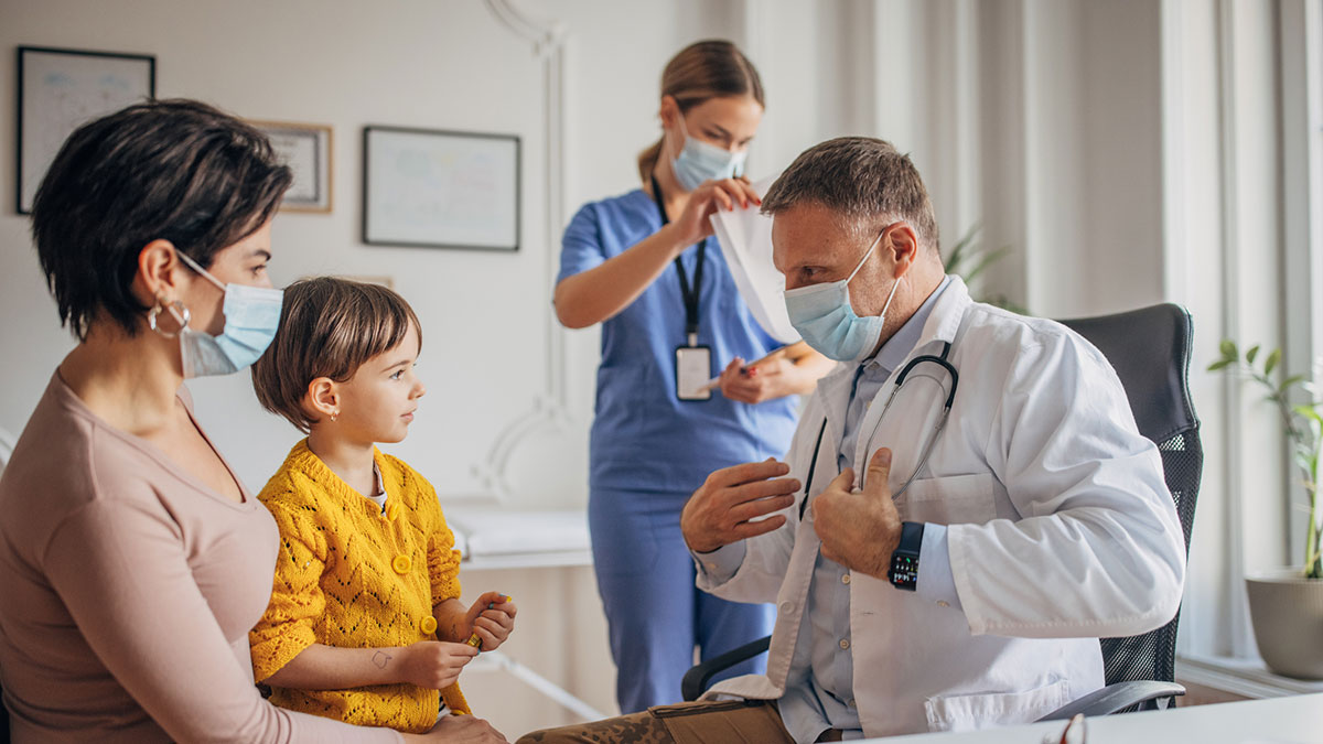 A mother and her child meeting with their doctor