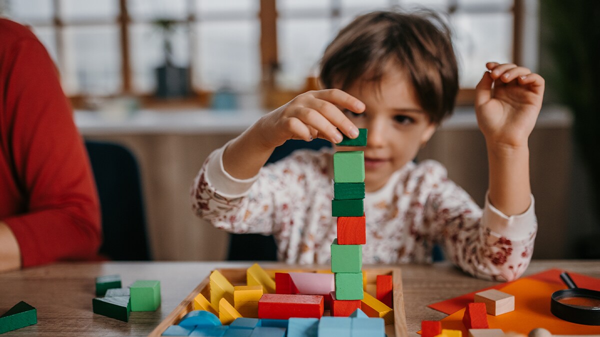 child playing with blocks by stacking them