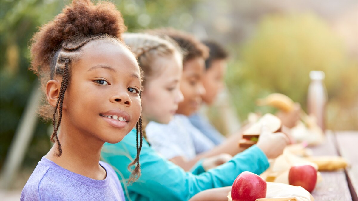 girl looking at camera while at lunch with her friends