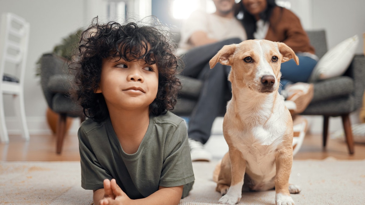 Boy and dog lying down and parents sitting on the couch.