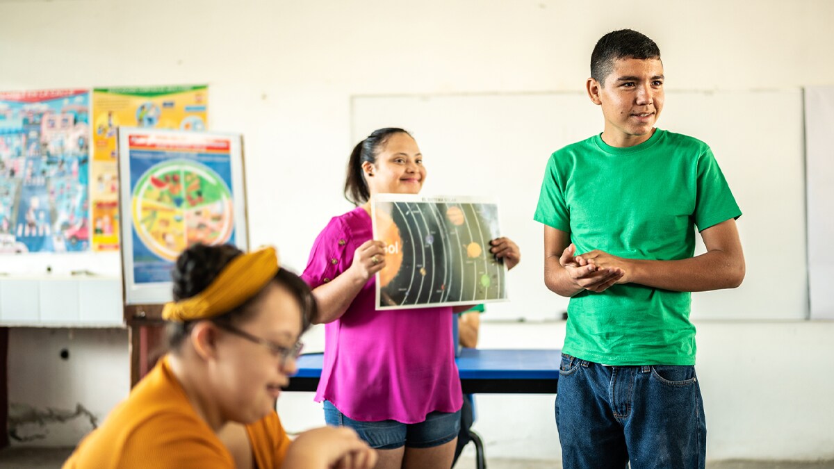 Three students with disabilities presenting a project in a classroom.