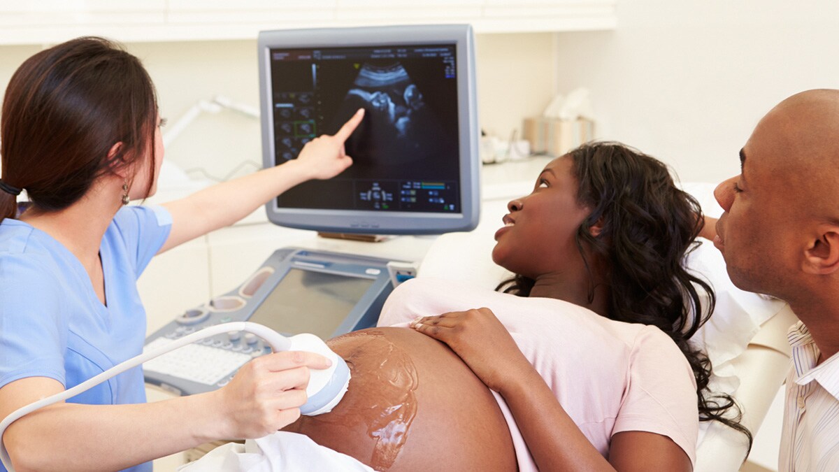 Doctor performing ultrasound on pregnant woman