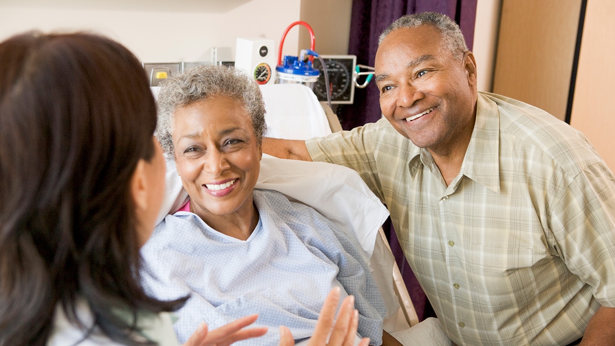 A doctor talking with a senior couple.