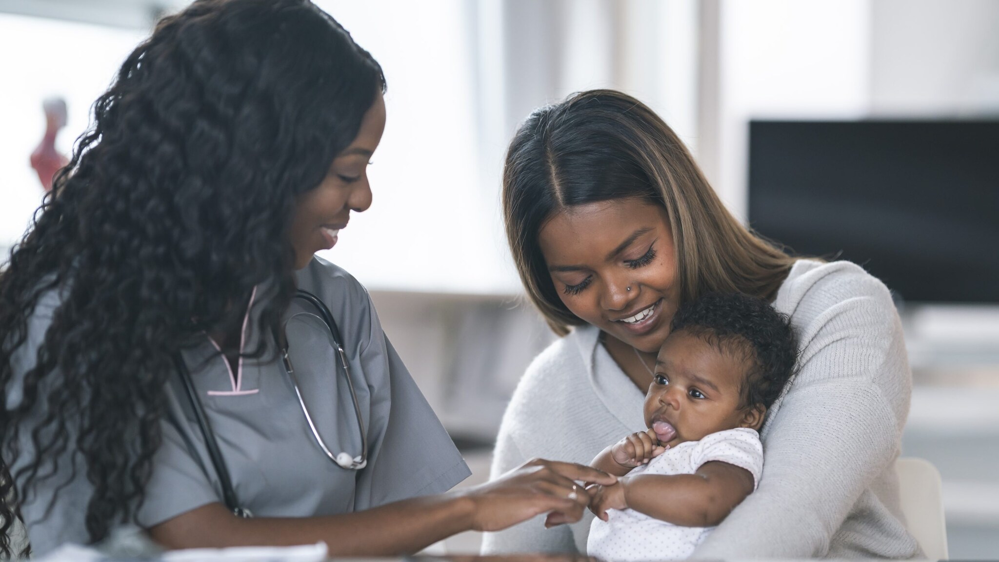 Mom and baby talking to a doctor.