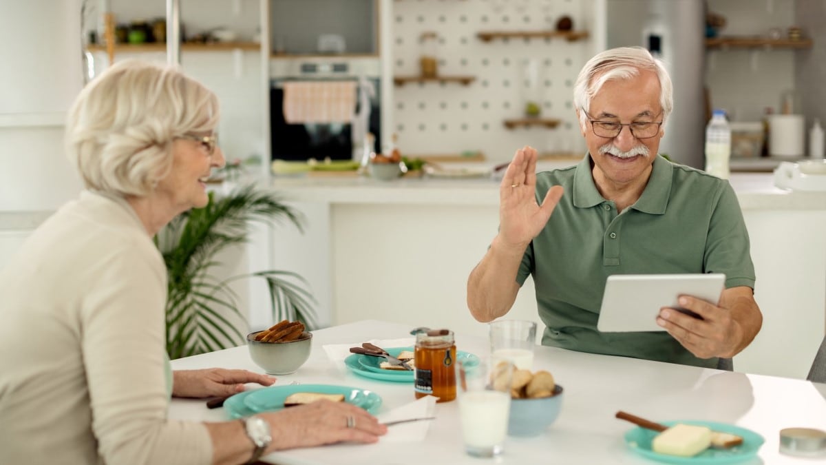 a mature man making a video call on a digital tablet at home