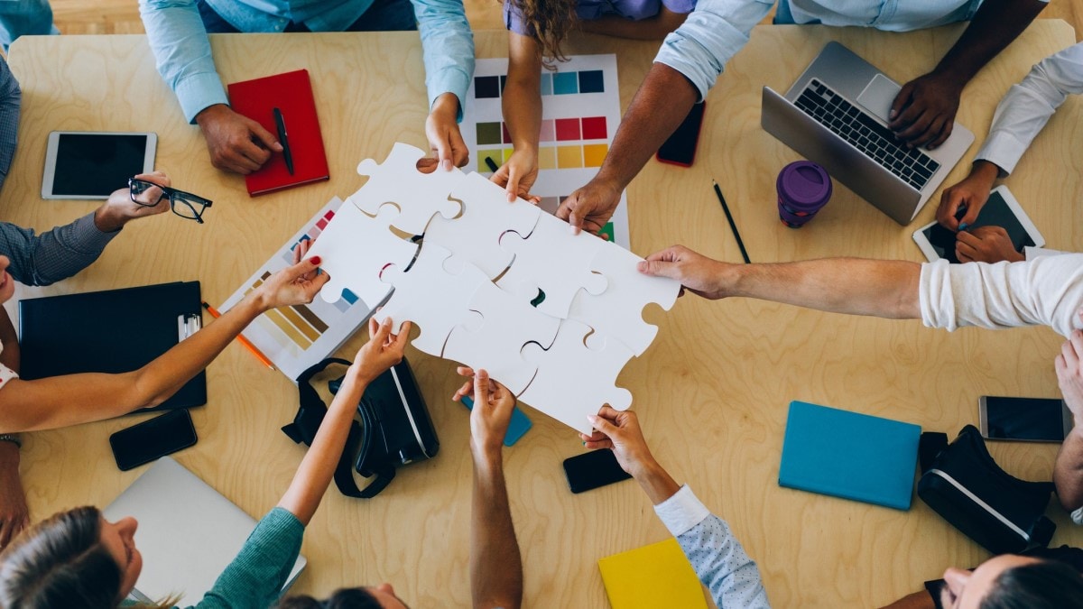 A group of racially diverse people puts a puzzle together