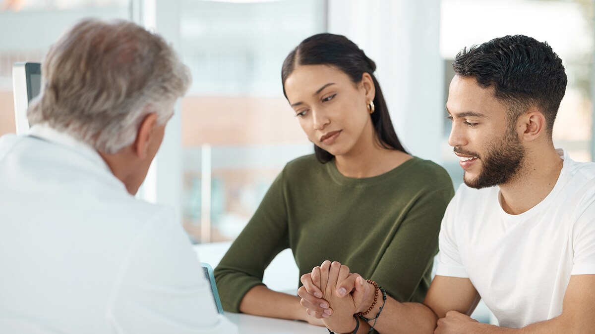 A young couple speaks with a doctor about pregnancy.