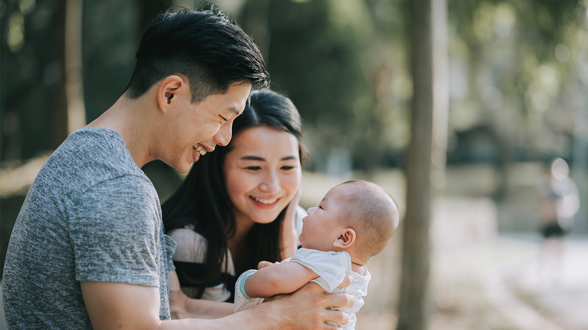 A dad and mother holding their baby.