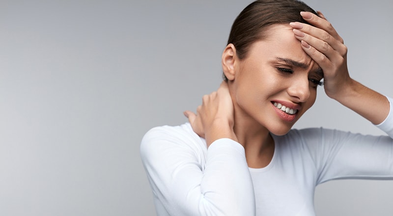 Woman feeling sick and experiencing headache.