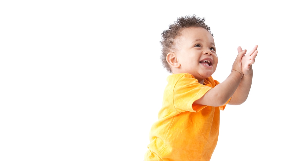 A giggling toddler clapping his hands