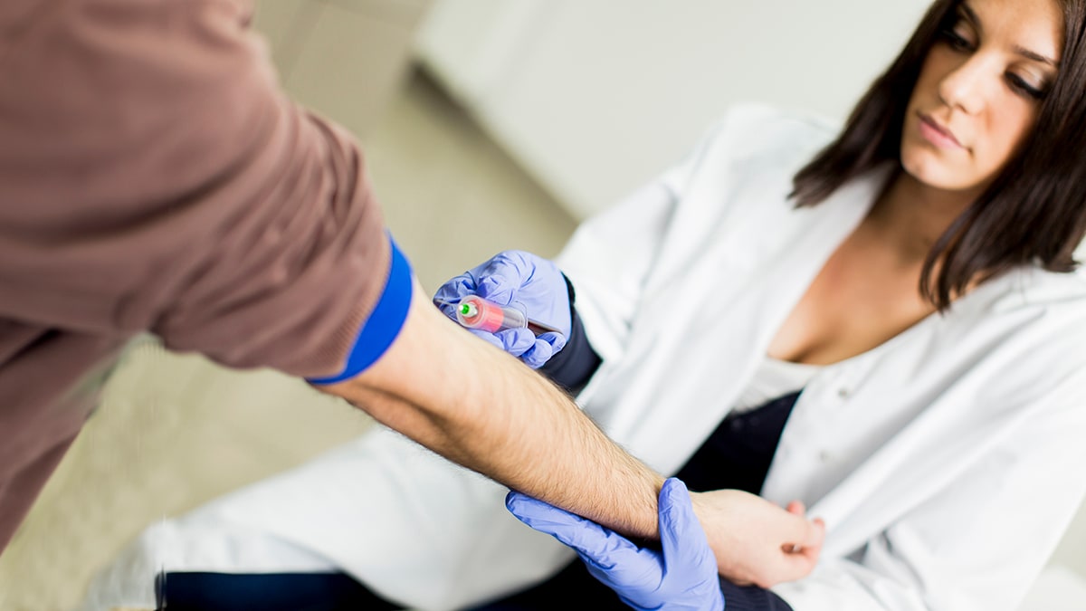 Man getting his blood drawn by a nurse for a cholesterol screening test.