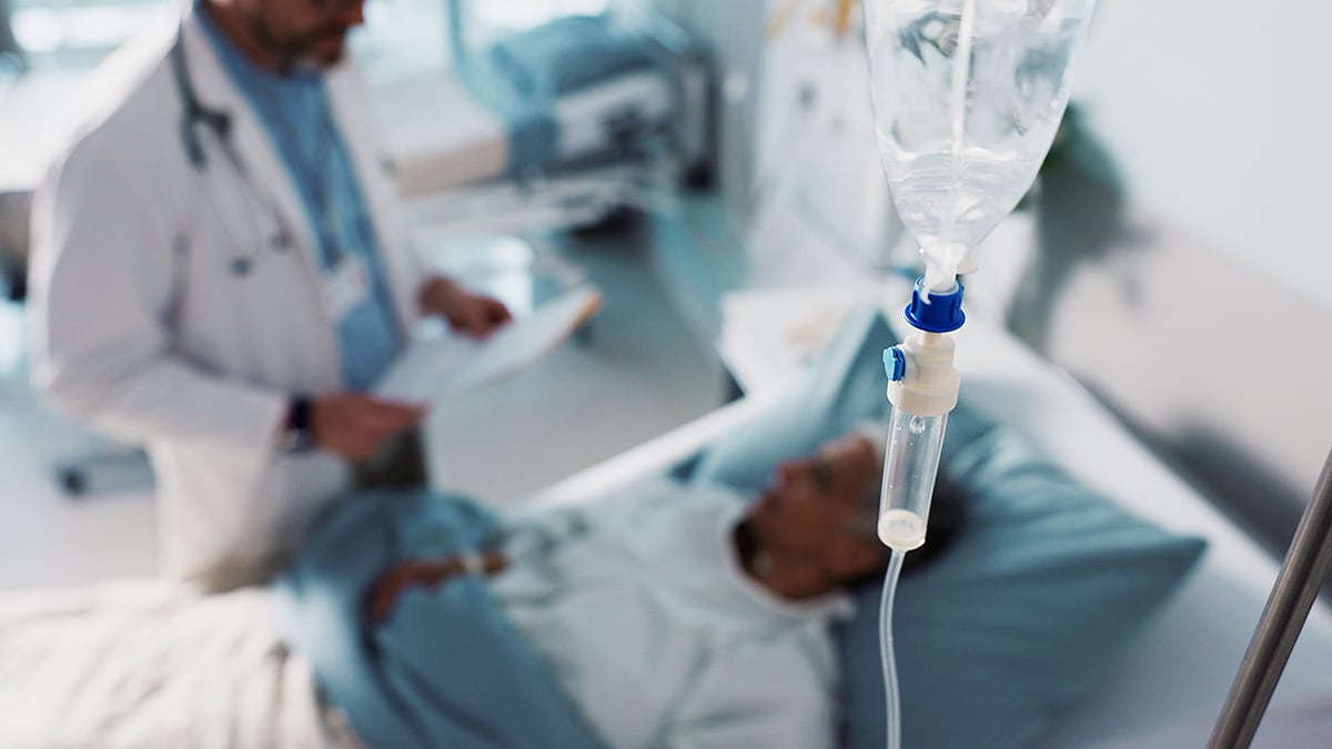 Photo of a healthcare worker attending to a patient with a central line IV