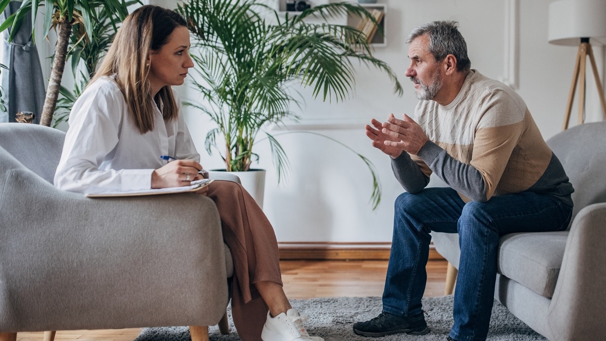 A man speaks to a genetic counselor in her office