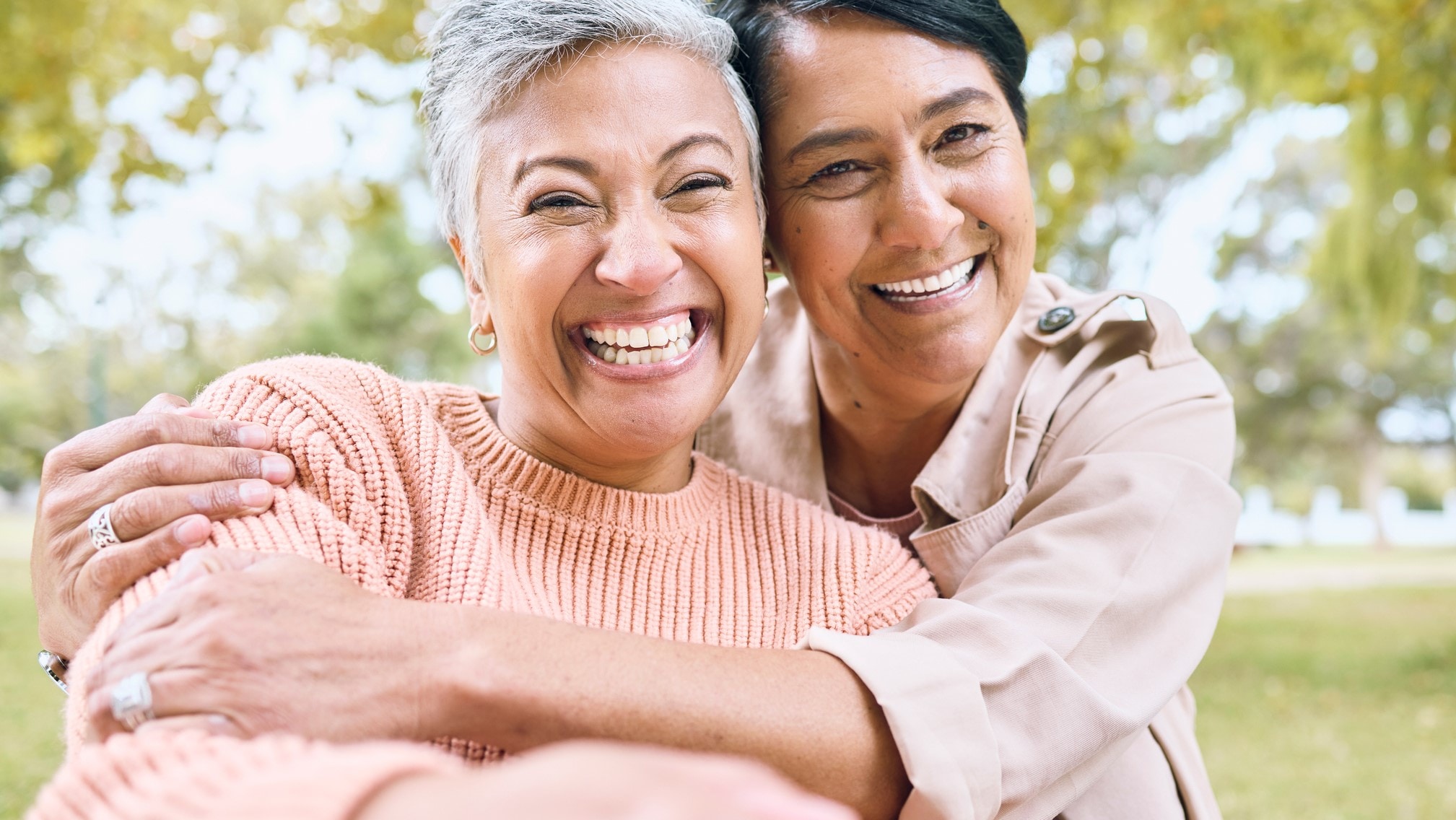 Smiling happy older adult friends hugging