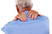 Elderly man massaging shoulder and neck muscles.