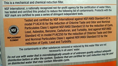 Filter label showing a description of NSF standards the product meets. The description says, "Tested and certified by NSF International against NSF/ANSI Standard 42 in model P1AC416 for the reduction of Chlorine Taste and Odor and Nominal Particulates Class I; against NSF/ANSI Standard 53 for the reduction of Cysts, Lead, Asbestos, Benzene, Carbofuran, and Turbidity. And against NSF/ANSI Standard 42 in model P1AC250 for the reduction of Chlorine Taste and Odor and Nominal Particulates Class I; against NSF/ANSI Standard 53 for the reduction of Cysts, Lead and Turbidity.