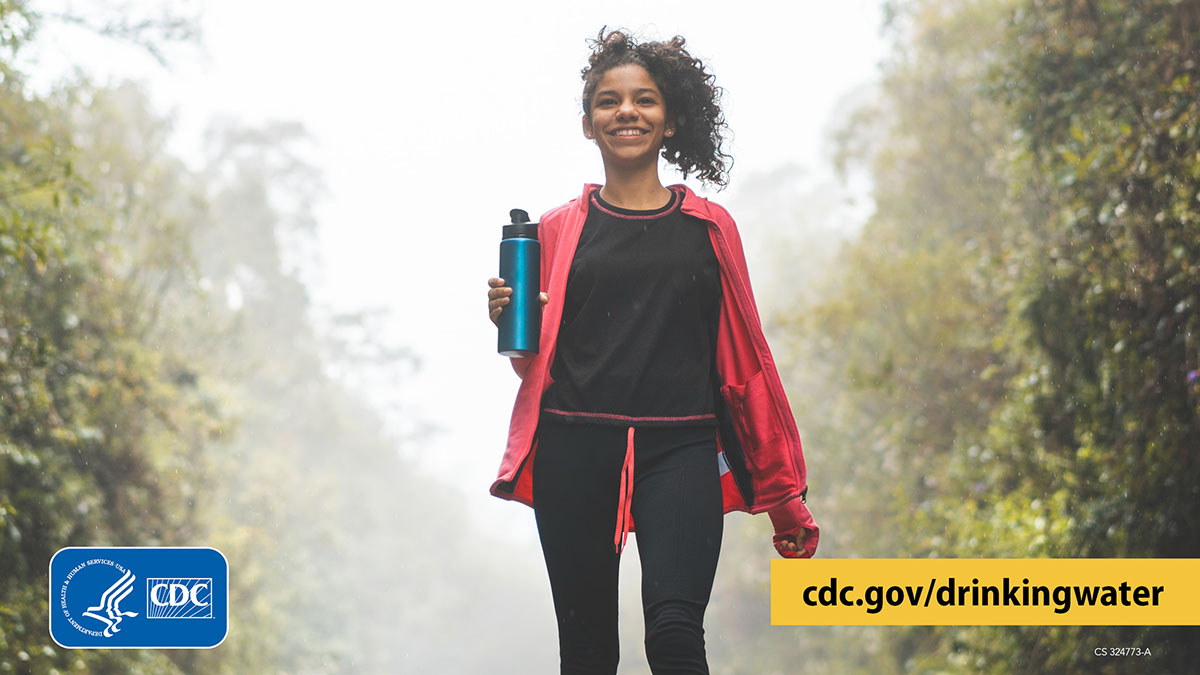 Smiling hiker carrying a reusable water bottle
