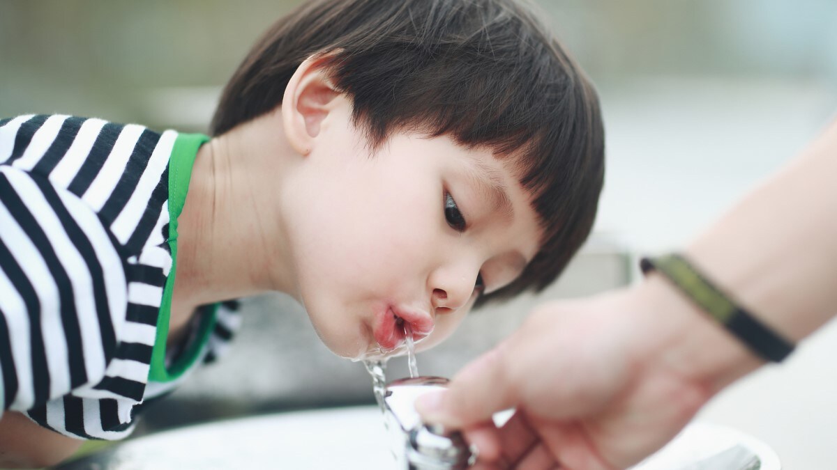 Child drinking water from a drinking water fountain