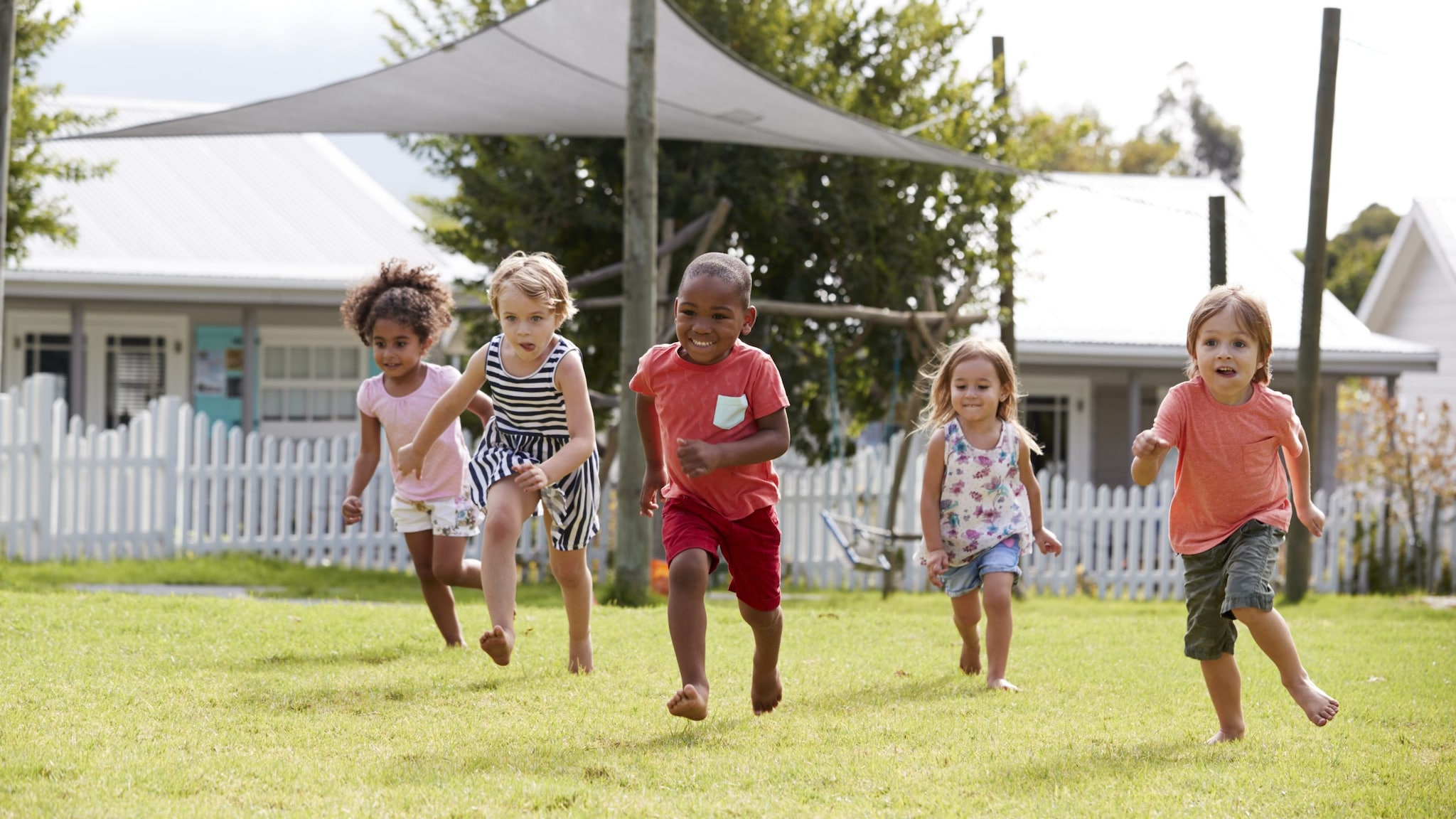 Children running outside in an open field.