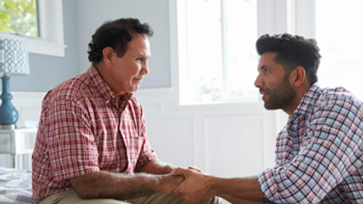 Younger man helping an older man