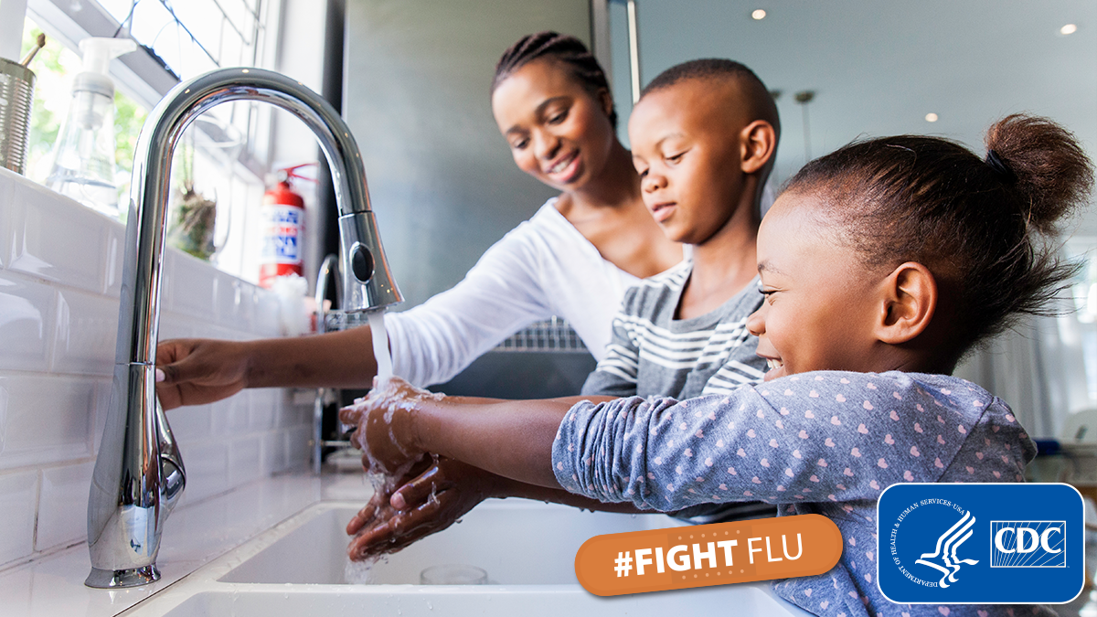 A family lathers soap in their hands and washes them under running water. A family lathers soap in their hands and washes them under running water.