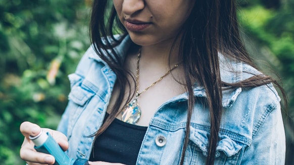 A girl holding a nebulizer for asthma.