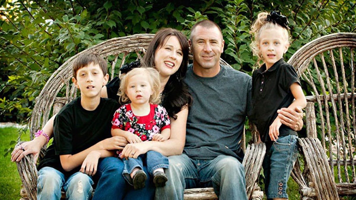 family sitting on bench with all three children that have fxs