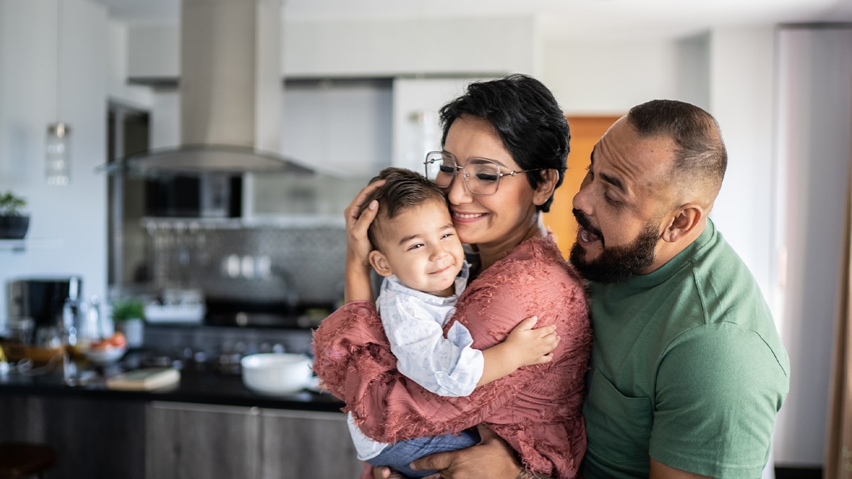 Una familia junta, con el bebé en brazos de la madre.