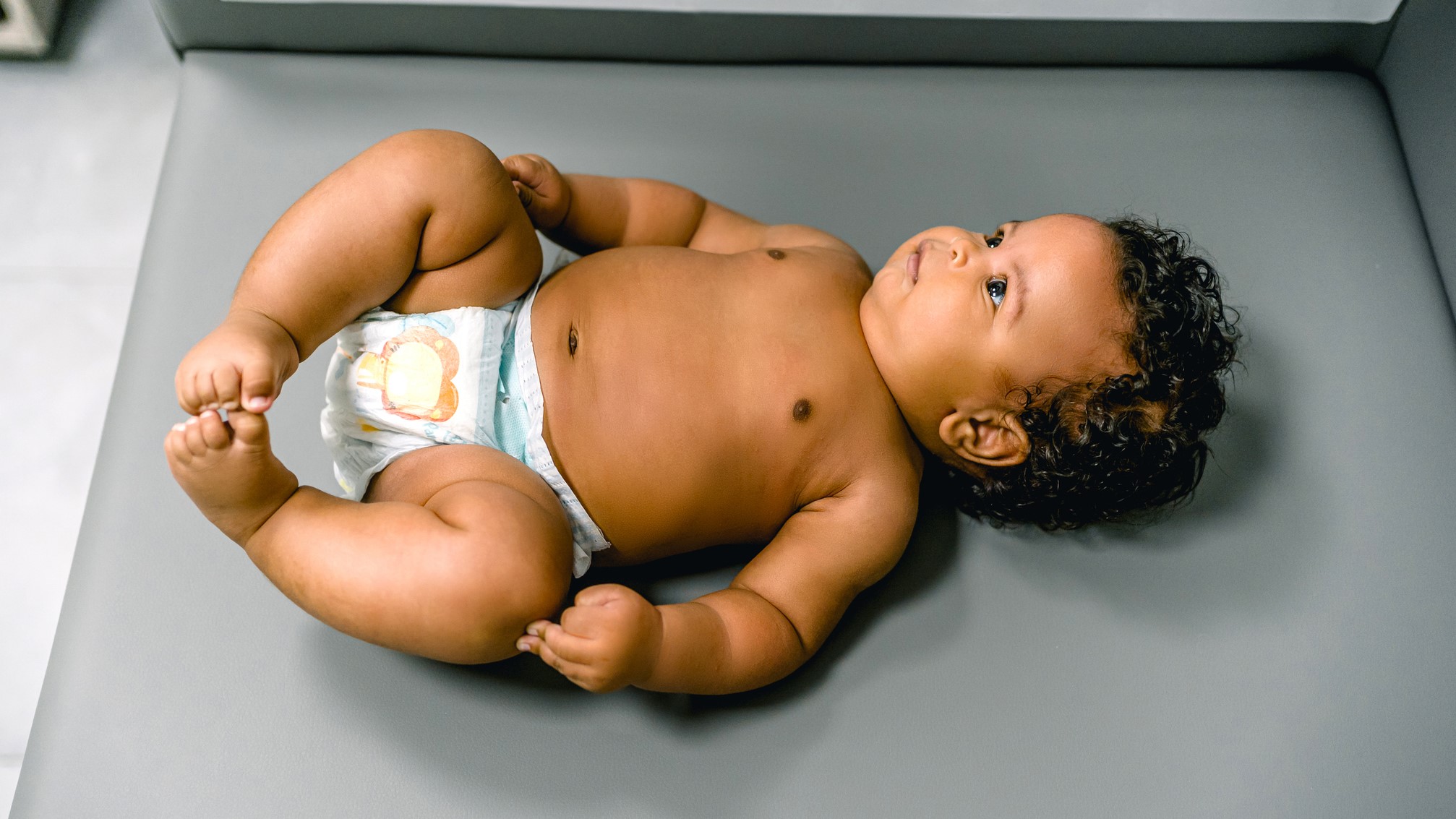 infant lying down baby wearing a diaper lying down to get length measured