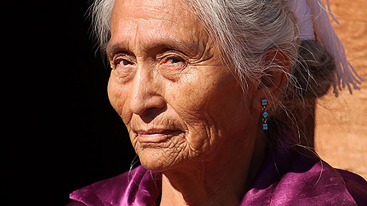 Close up of an older, American Indian woman with gray hair.