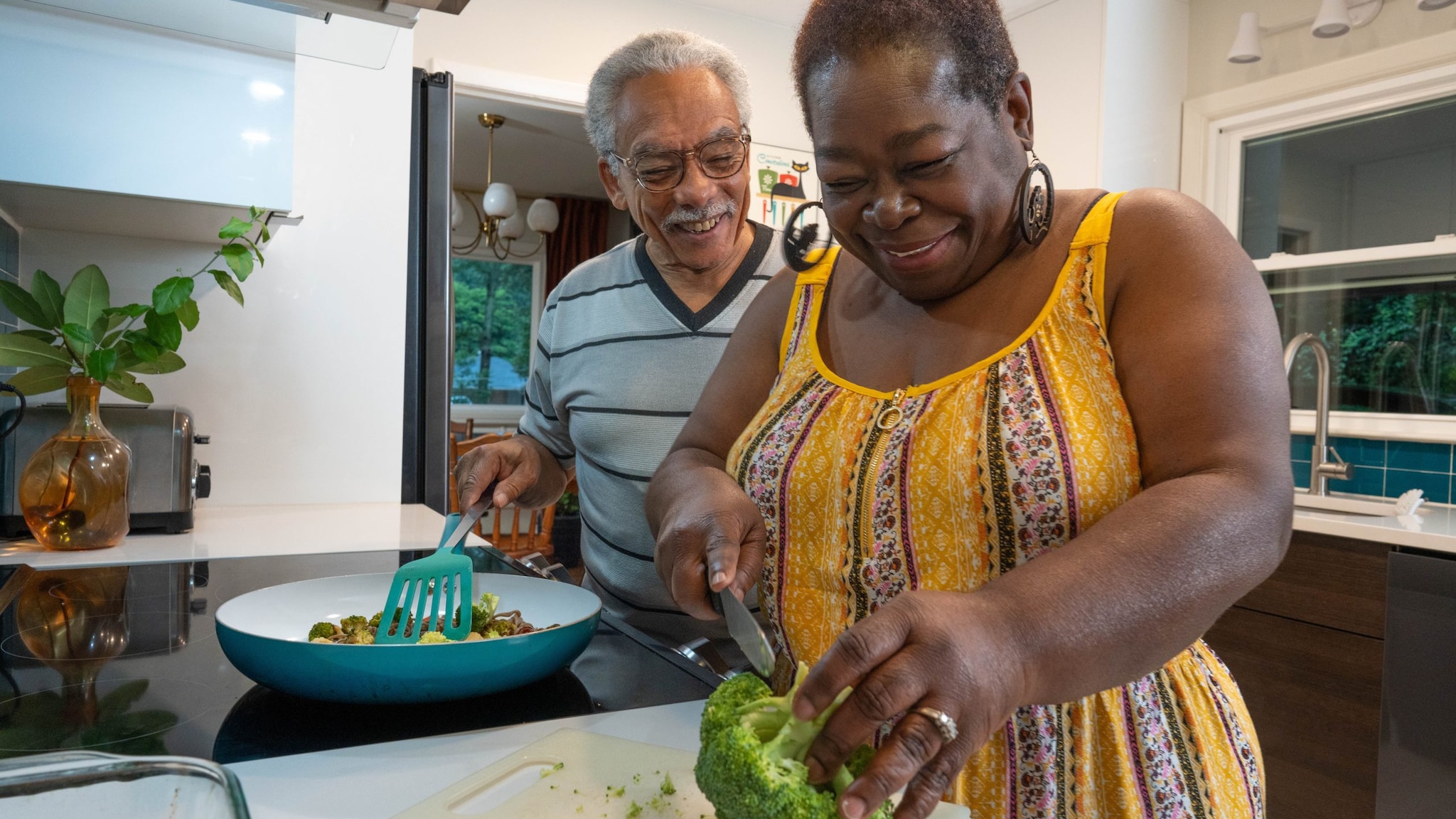 Couple making a meal on the stovetop in a home kitchen.