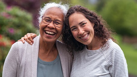 Mother and daughter smiling and posing for camera.