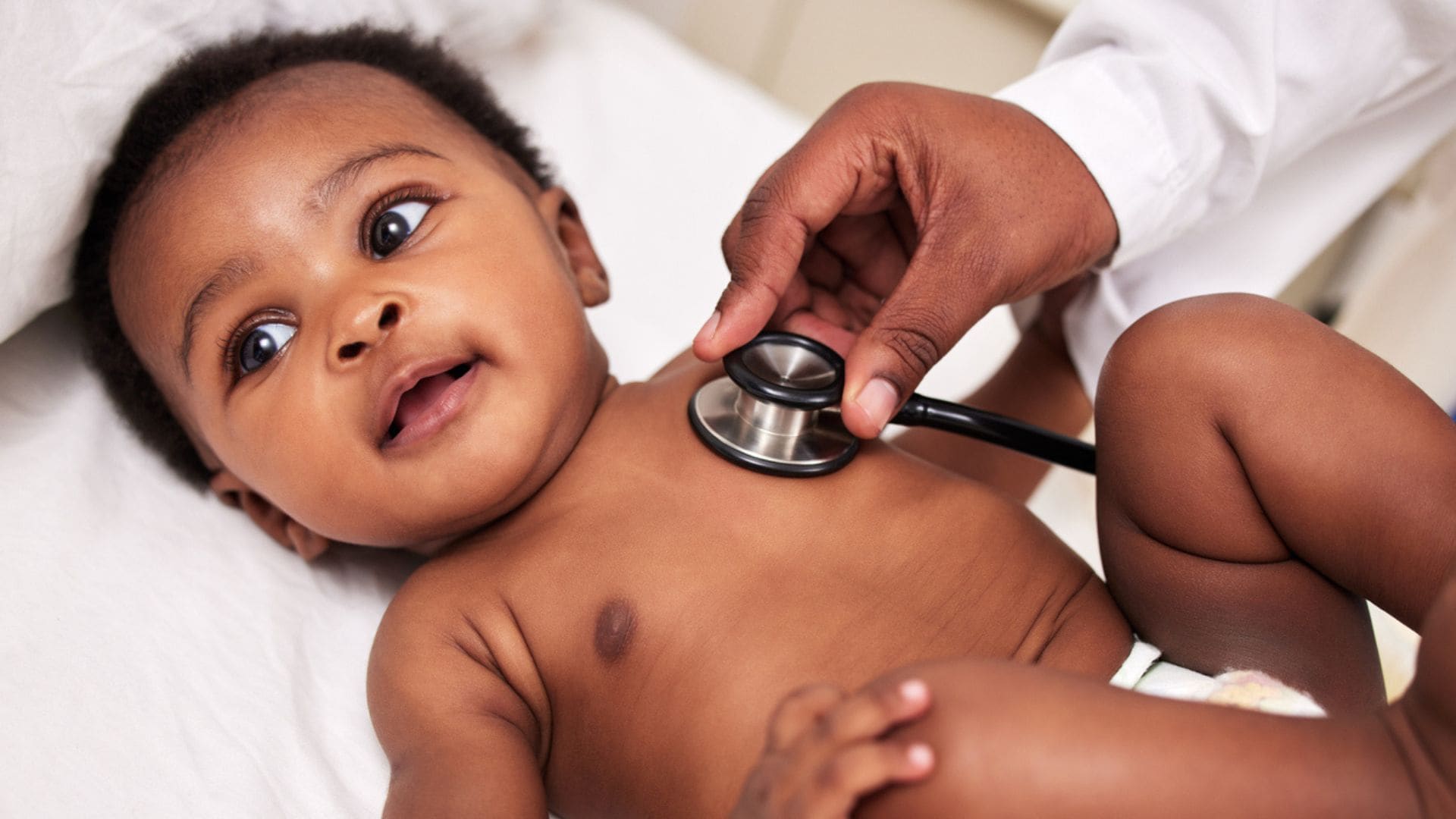 A Heathcare worker is listening to a baby's heart