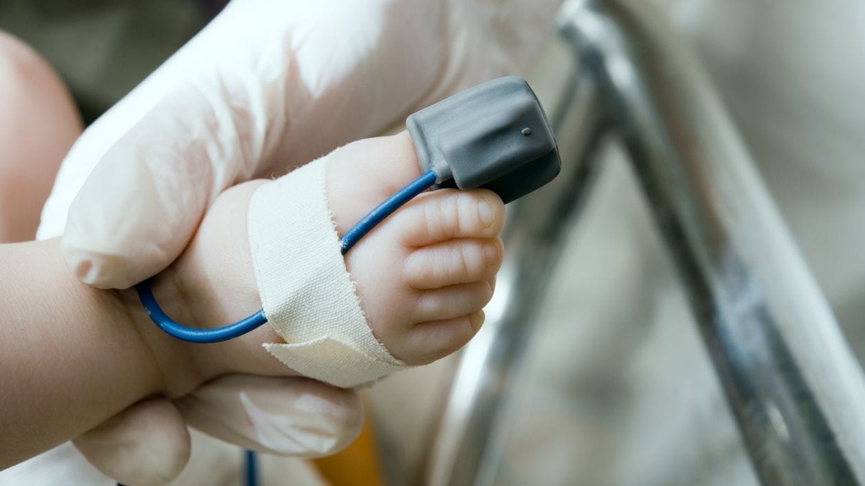 A pulse oximeter on a baby's foot