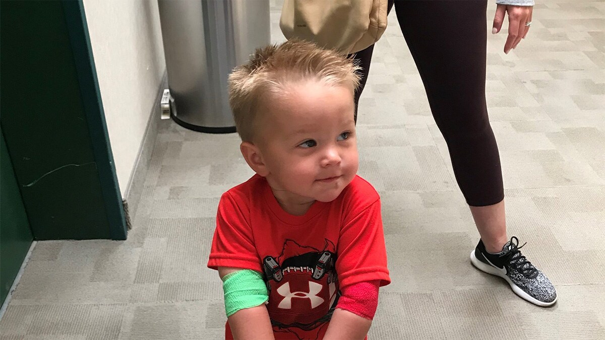 Male toddler with bandages wrapped around his arm after receiving treatment