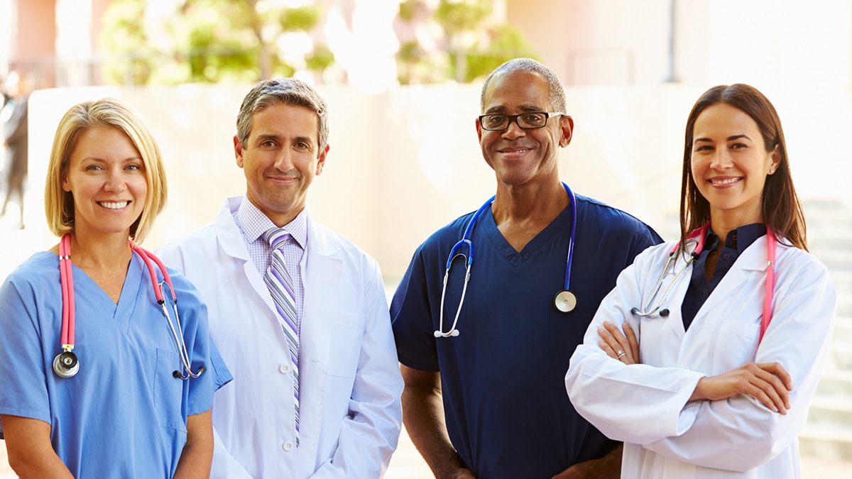 Four doctors and nurses smiling