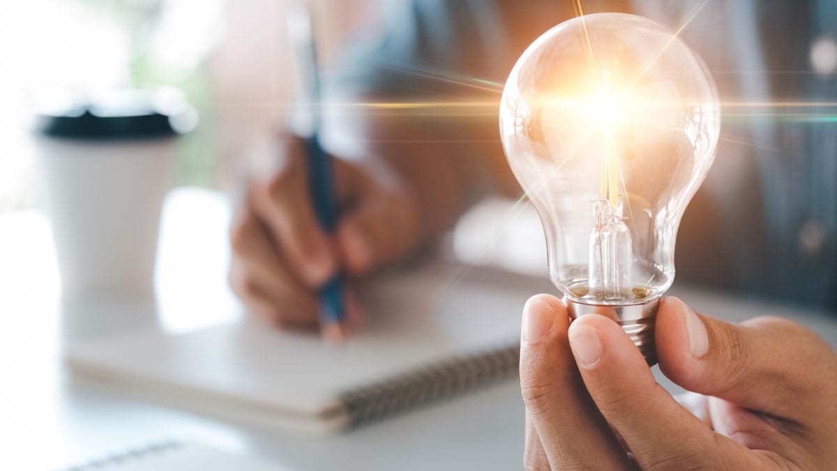 A hand holding a lightbulb