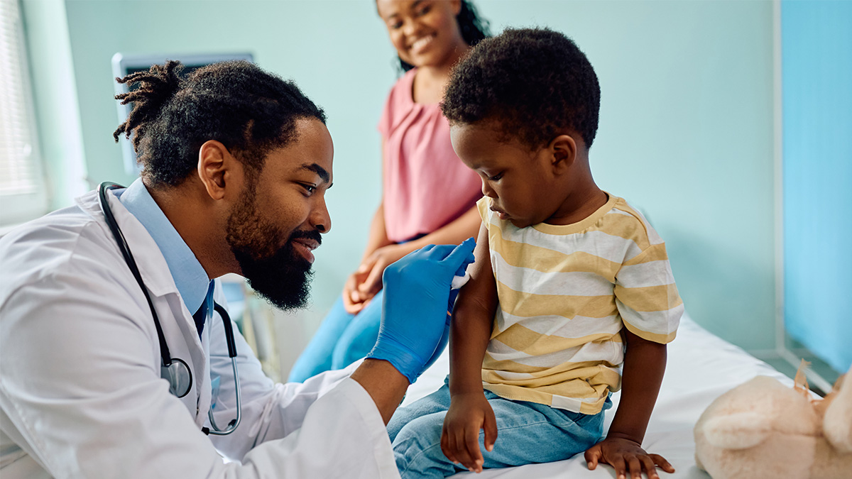 A mother and child meeting with a healthcare professional to give the child a vaccine