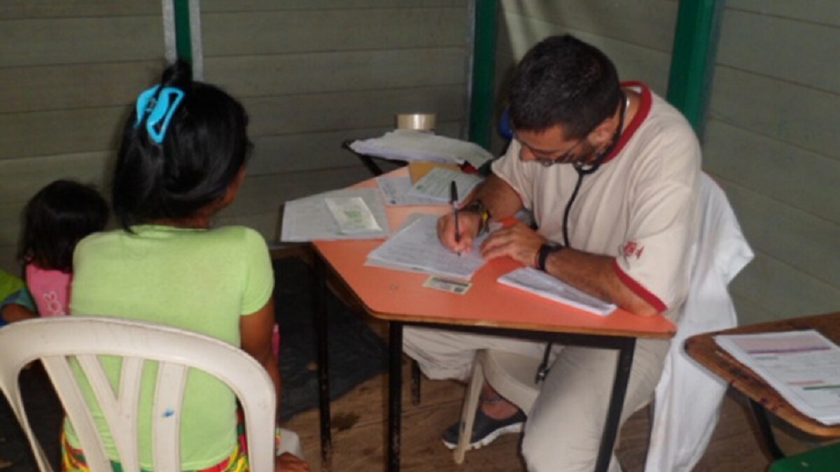 doctor writing in charts at a desk