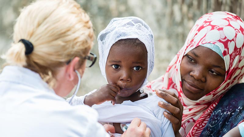 Doctor examining young child