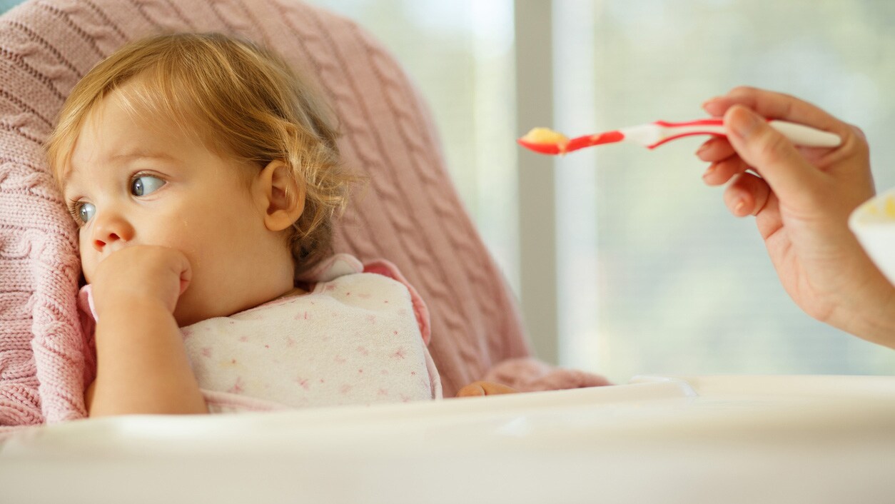 A child turning her head away from food.