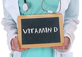 A physician holding a sign saying vitamin D.