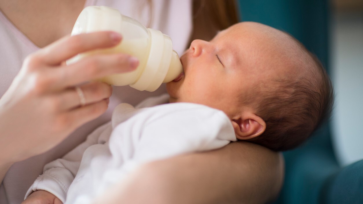 Infant drinking from a bottle.