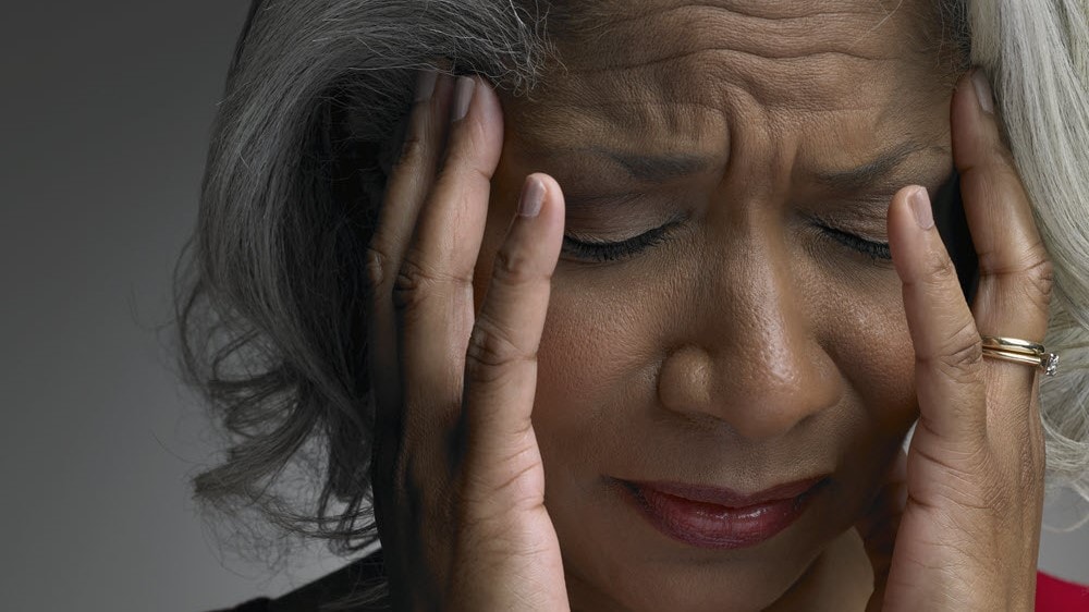 Woman holding her head in pain