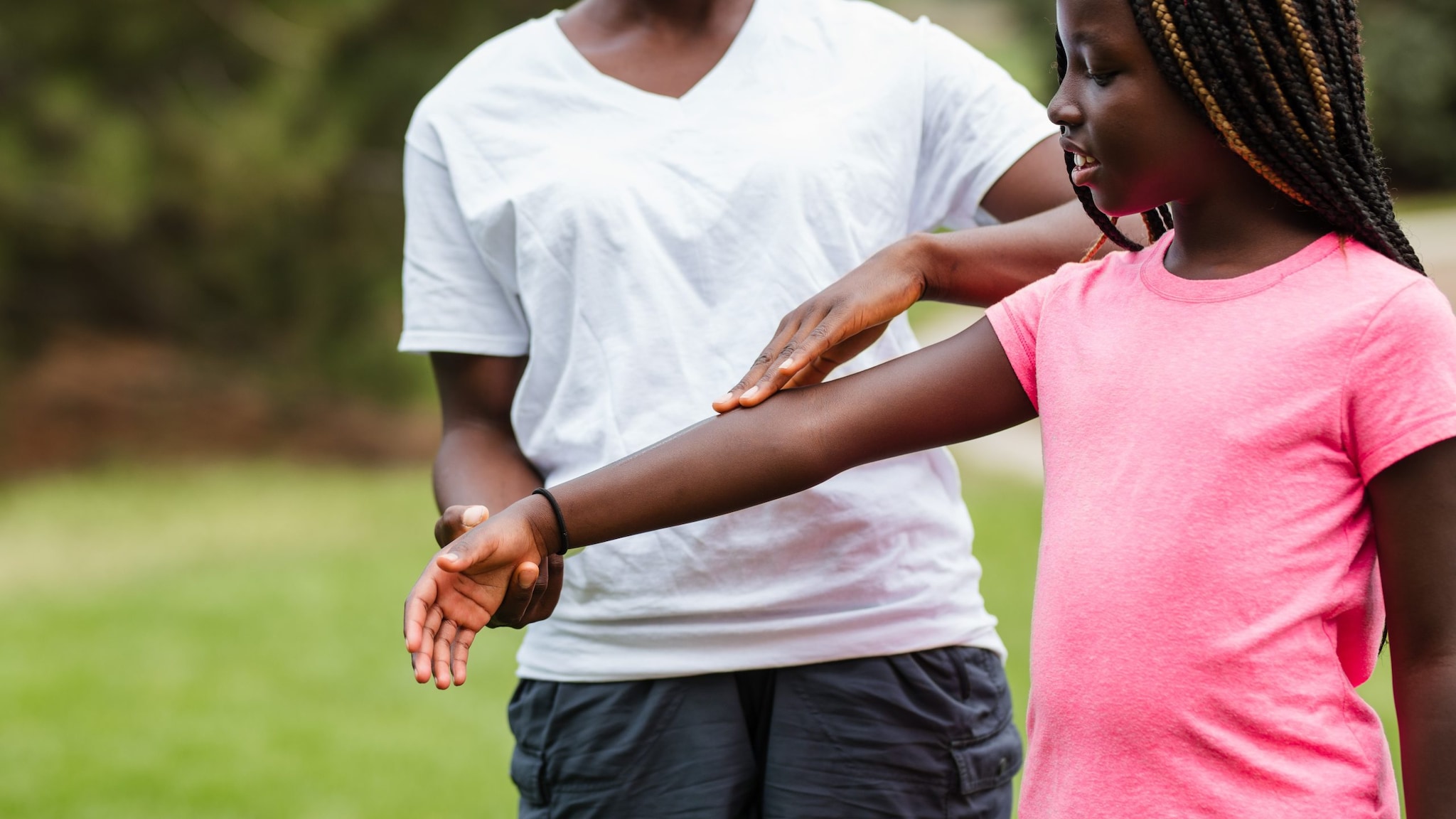 Parent helping apply insect repellent to their child