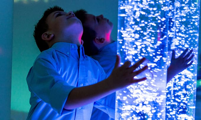 Boy looking at tube of lights