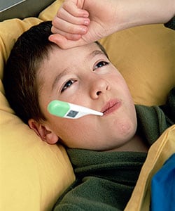 boy on his bed with a thermometer suffering from mumps